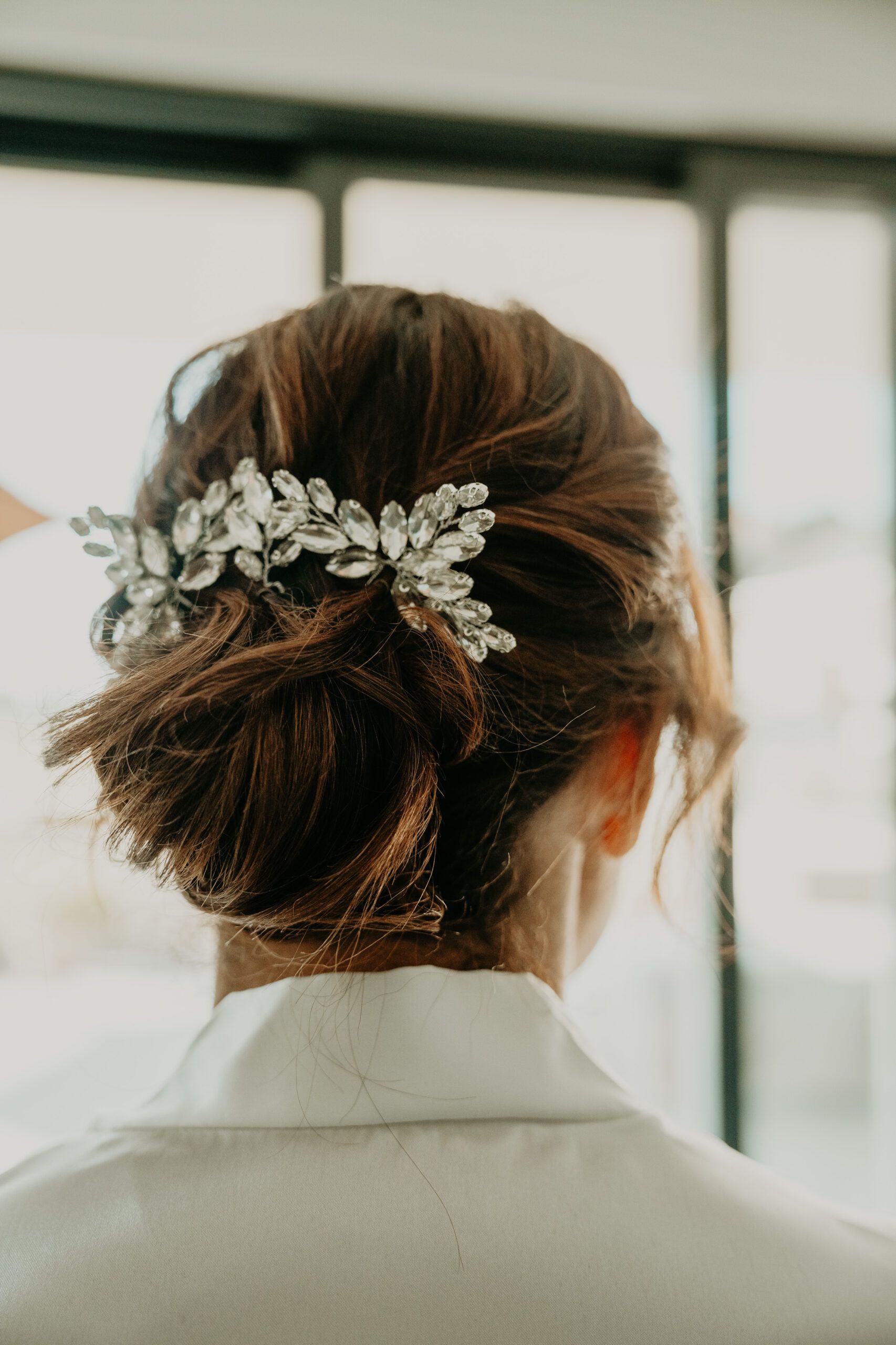 Le chignon de la mariée, orné d’un bijou de cheveux, vu de dos.