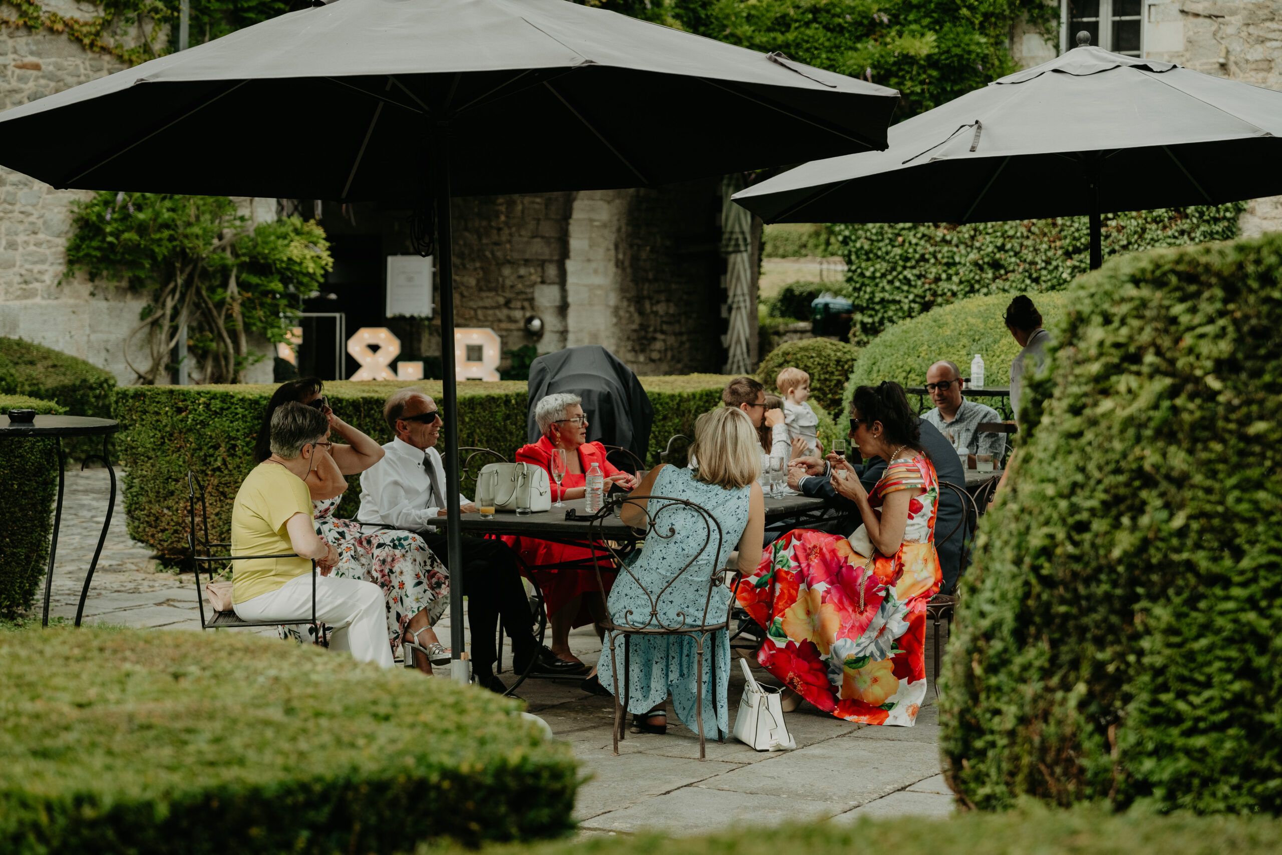 Le vin d’honneur sous les parasols, dans les jardins d’un château.