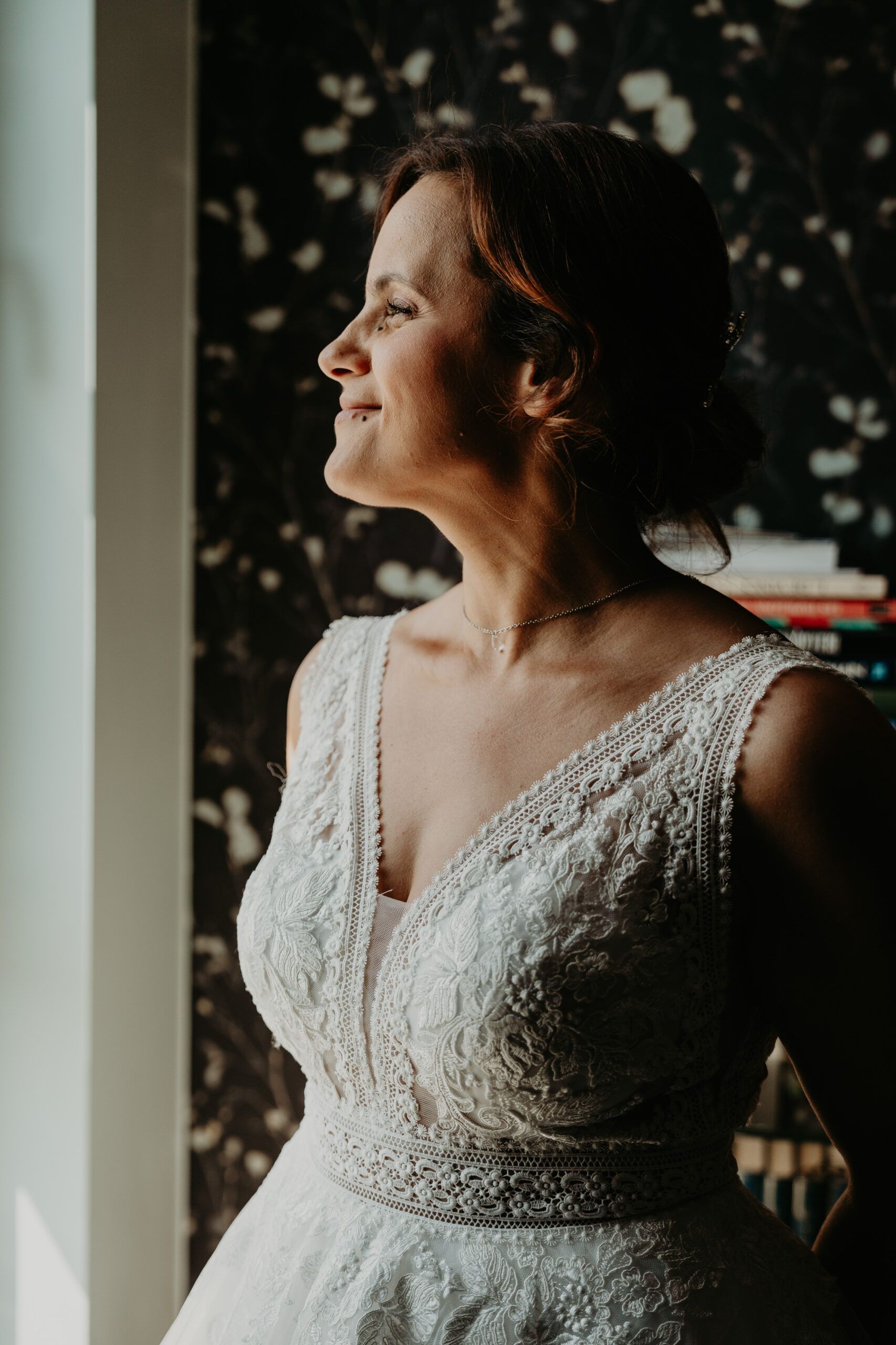 Laura, en robe de mariée, le regard levé vers la lumière.