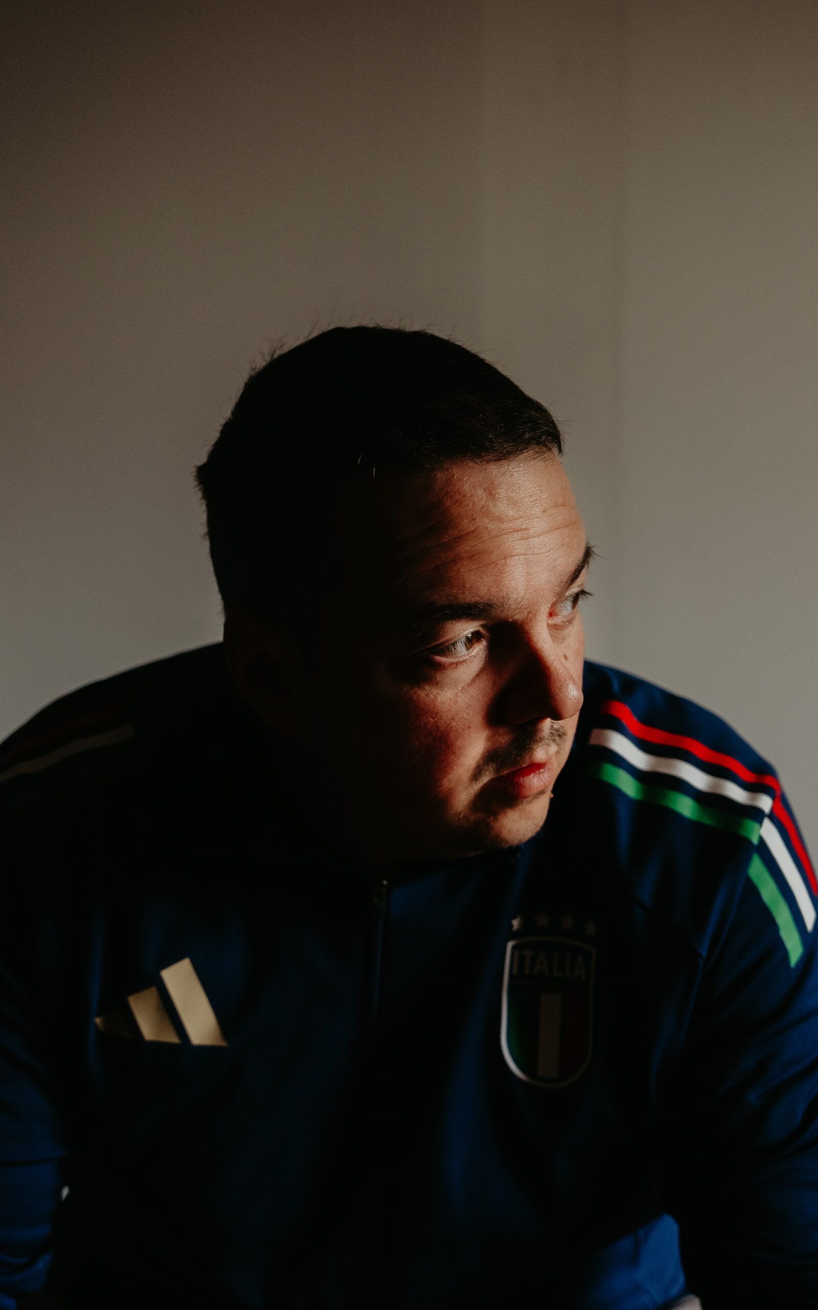 Portrait de Kevin en clair-obscur, le regard tourné vers la lumière.